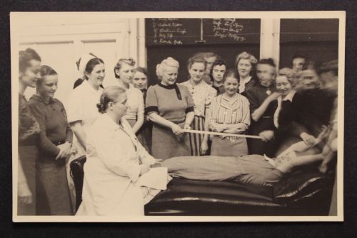 Frauengruppe, evtl. Krankenschwestern, Lehrvorführung o. ä.