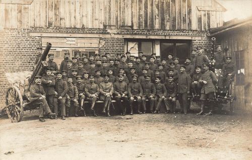Fotokarte 1.WK Gruppenfoto Soldaten mit Geschütz vor Stellmacherei Werkstatt