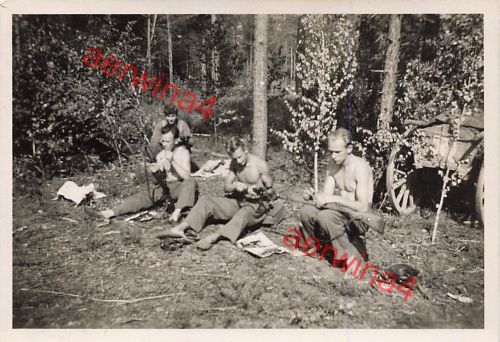 Deutsche Soldaten Waffenreinigung im Wald mit getarnten Geschütz