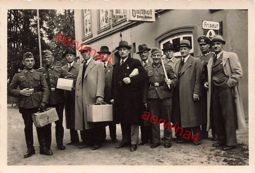 Deutsche Soldaten mit Zivilisten vor der Einberufung am Gasthof und Friseur