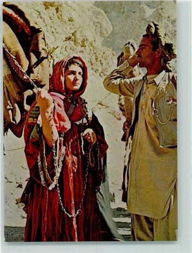 Koochi nomad girl leading her camel on the mountain rads