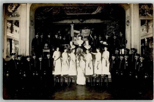 Flensburg 1914 Saal Bühne Gruppenaufnahme Post-Unterbeamten-Verein Junge Damen Postbeamte Ort lt. Stempel