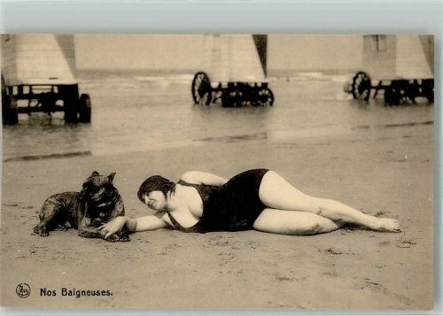 Frau im Badeanzug mit Boxer vor Badekarren am Strand