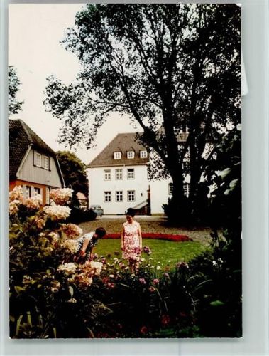 Holzhausen Frau trägt Blumenkleid