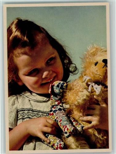 Mädchen strahlt den Teddybär an