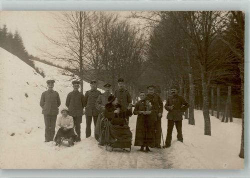 Gruppenaufnahme von Landser in Uniform mit zwei Frauen auf Schlitten im Schnee Deutsches Heer WK I Privatfoto AK