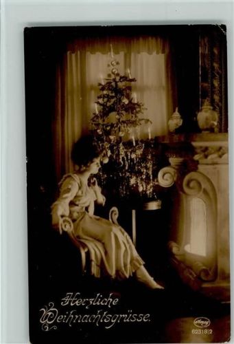 Frau sitzt alleine am Kamin, geschmückter Weihnachtsbaum