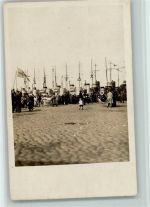Menschen strömen zum Hafen, dort liegen Kriegsschiffe Marine
