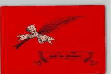 Ein Reisigbesen mit einer Schleife und dem Teufel Krampus