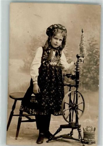 1910 Mädchen in Tracht an einem Spinnrad