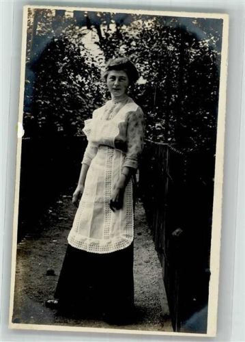 Junge Frau mit weißer Schürze im Garten