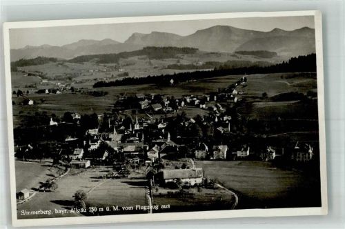 87496 W8961 Simmerberg , Allgäu Foto AK Fliegeraufnahme des Ortes mit Kirche St. Joseph