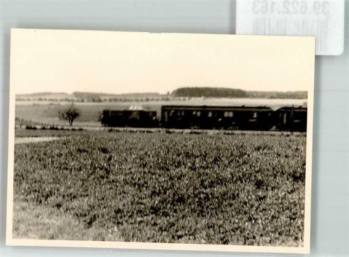Diesellok zieht Reisewaggons durch die weite Landschaft
