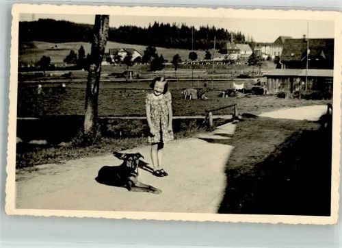 Ein Mädchen mit seinem Hund auf der Dorfstraße