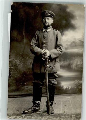 Deutscher Kavallerist in Uniform mit Schirmmütze Säbel und Sporen an den Reitstiefeln im Fotostudio