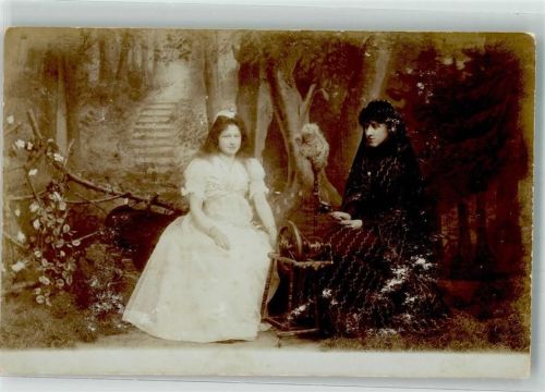 Eine weiß und eine in schwarz gekleidete Frau am Spinnrad im Fotostudio