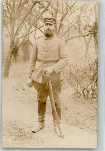 Ein bärtiger deutscher Landser in Uniform mit Säbel