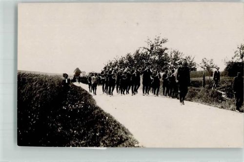 Eine uniformierte Marschkapelle auf einem Feldweg