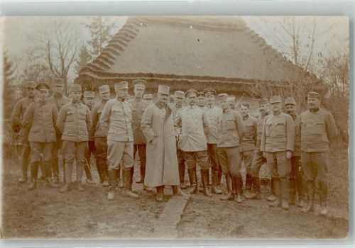 Gruppenaufnahme von Landsern in Uniform vor einer Strohgedeckten Hütte Zweibund WK I