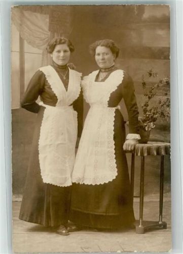 Zwei junge Frauen mit weißen Schürzen im Fotostudio