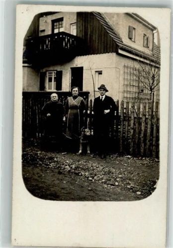 Bewohner mit Hund vor ihrem Haus