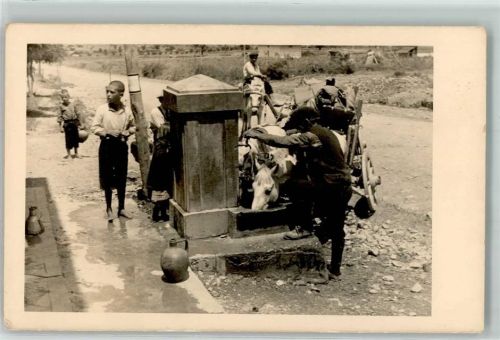 Brunnen dient als Pferdetränke und Kinder holen dort Wasser