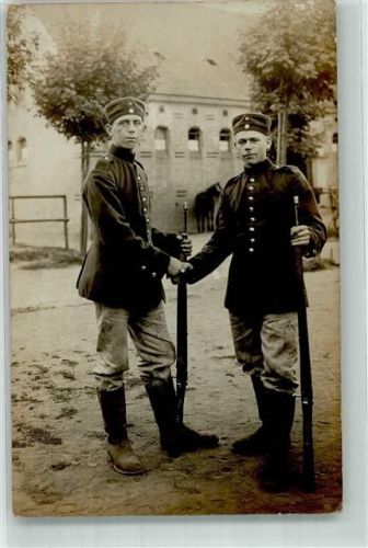 Zwei junge Landser in Uniform mit Karabiner reichen sich die Hand