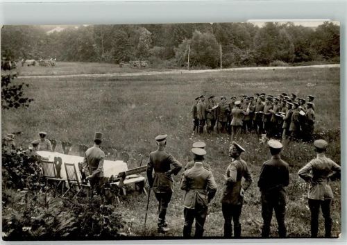 Offiziere neben einem weiß gedeckten Tisch lauschen dem Militärchor