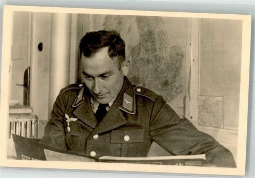 Deutscher Landser in Uniform beim Lesen in einer Zeitschrift