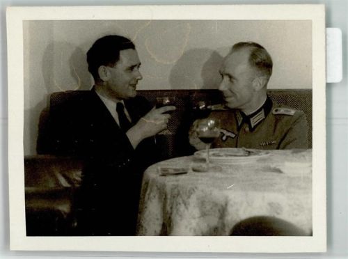 Ein deutscher Hauptmann im Gespräch bei einem Glas Wein mit einem Zivilisten