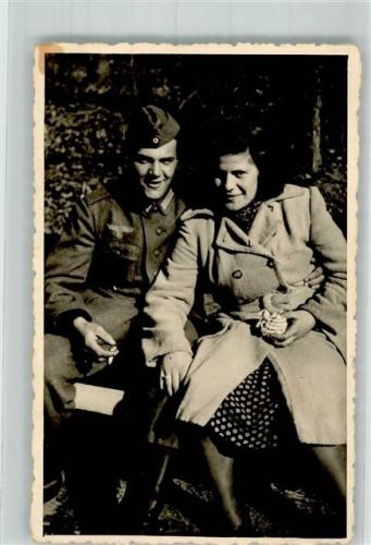 Landser der Wehrmacht in Uniform mit Zigarette und seiner Liebsten neben sich