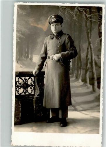 Ein Landser im langen Feldmantel im Fotostudio