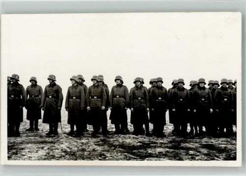 Angetretene Landser im Feldmantel mit Stahlhelm M16