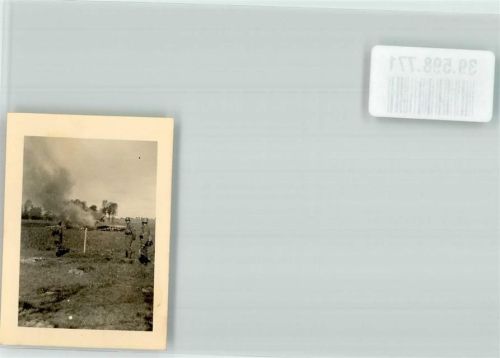 Wehrmachtssoldaten vor den rauchenden Trümmern eines abgeschossenen Flugzeuges