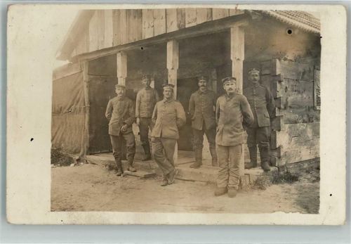 Eine Gruppe Landser in Uniform vor ihrem Unterstand