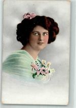 Dunkelhaarige Frau mit Blumenschmuck im Haar und im Ausschnitt Haarmode