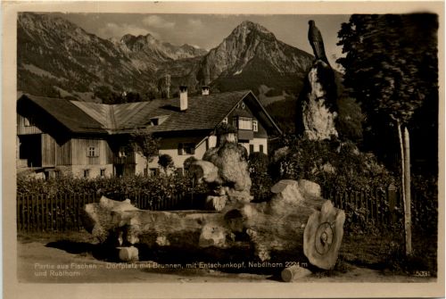 Partie aus Fischen, Dorfplatz mit Brunnen und Berge