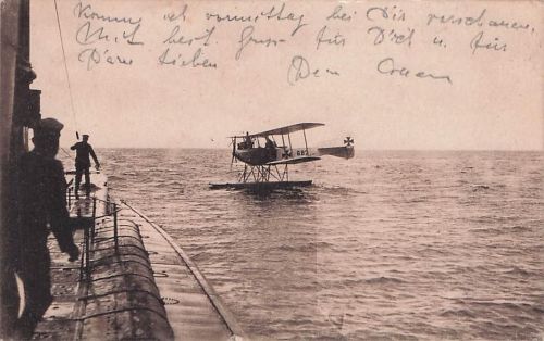 FF 33 Wasserflugzeug, das neben einem U-Boot im Meer schwimmt.