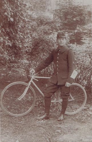 einen jungen Mann in Militäruniform, der mit einem Fahrrad posiert