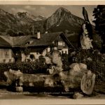 Partie aus Fischen, Dorfplatz mit Brunnen und Berge