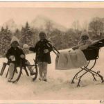Kinder mit Kinderwagen und Schlitten