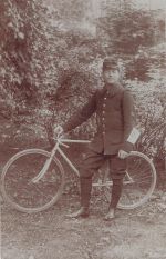 einen jungen Mann in Militäruniform, der mit einem Fahrrad posiert