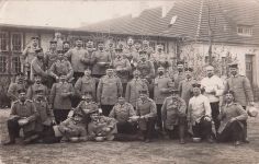 Gruppe deutscher Soldaten, möglicherweise Reservisten oder Landwehr, die während des Ersten Weltkriegs eine Mahlzeit einnehmen.