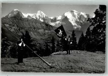 Foto E. Gyger Bläser u. Fahnenschwinger m. Eiger Mönch u. Jungfrau Alphorn