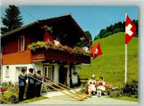 Alphornbläser und Frauen in Tracht vor einem Chalet Suisse Alphorn Foto AK