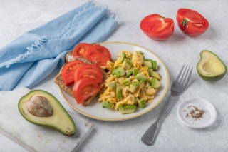 Roerei met avocado en een broodje tomaat