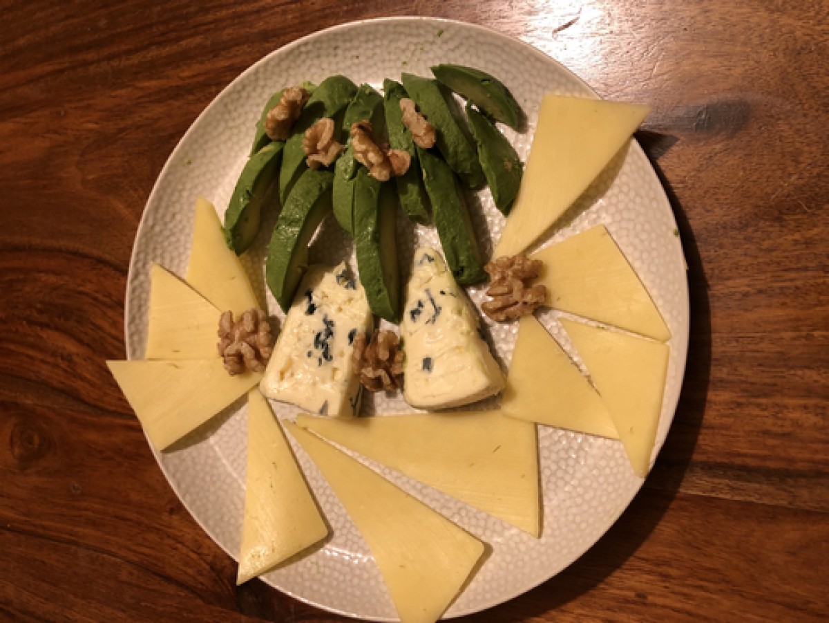 Cheese plate with nuts and avocado