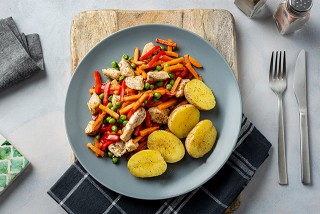 Poulet à l'étouffée aux petits pois et carottes accompagné de pommes de terre
