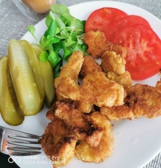 Schnitzel à la Schweinekoteletts in Mandelmehl paniert mit Gurke und Tomate