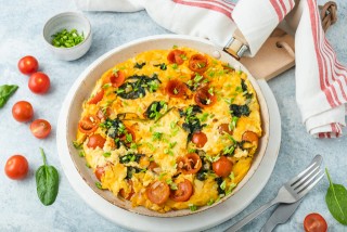 Curd cheese omelette with tomatoes, spinach and chives